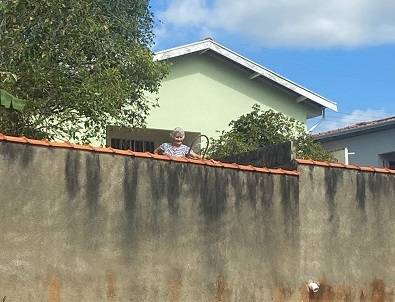 Fé sem barreiras: mulher usa escada para assistir a passagem das congadas